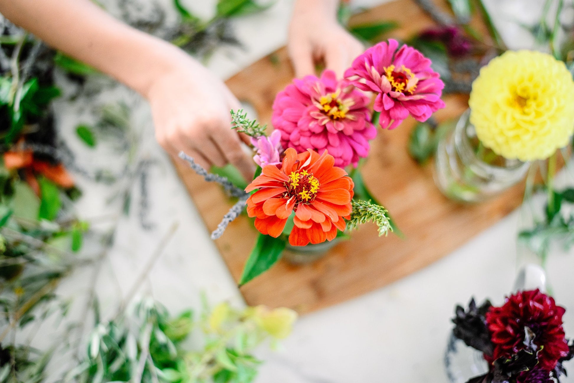 A kindergarten homeschooler arranging wild flowers in a mason jar.