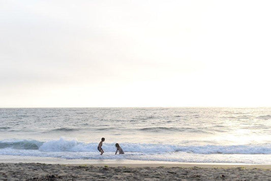 Homeschool kids playing in the ocean.