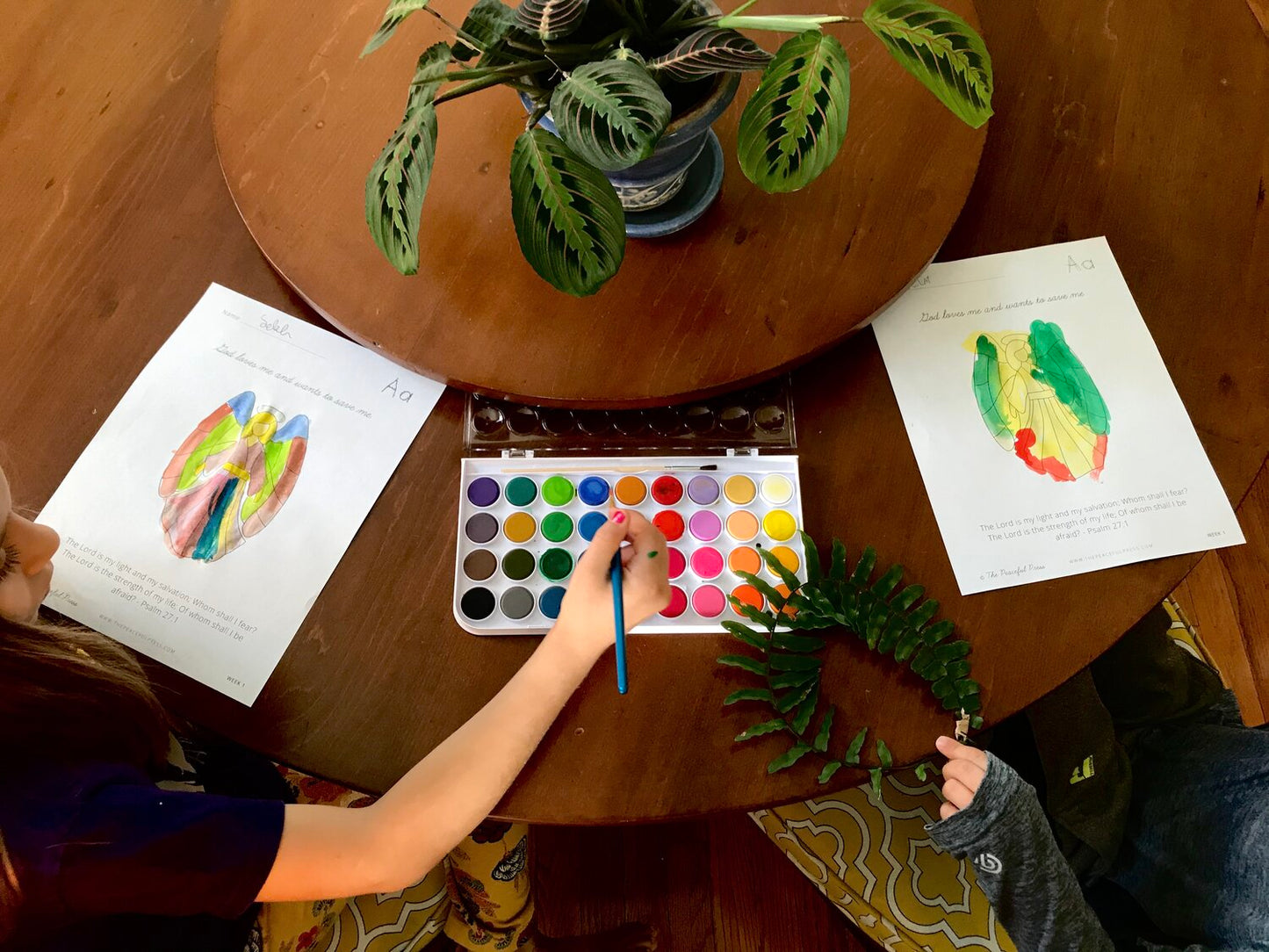 Homeschool Kids using water colors to paint a stained glass angel.