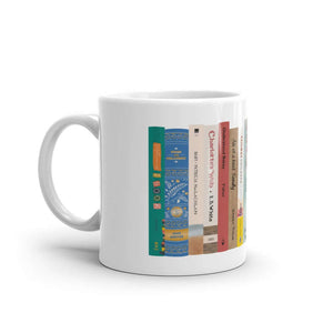 The Peaceful Preschool Mothering By The Book mug in white with a painting of a bookshelf with books on it.